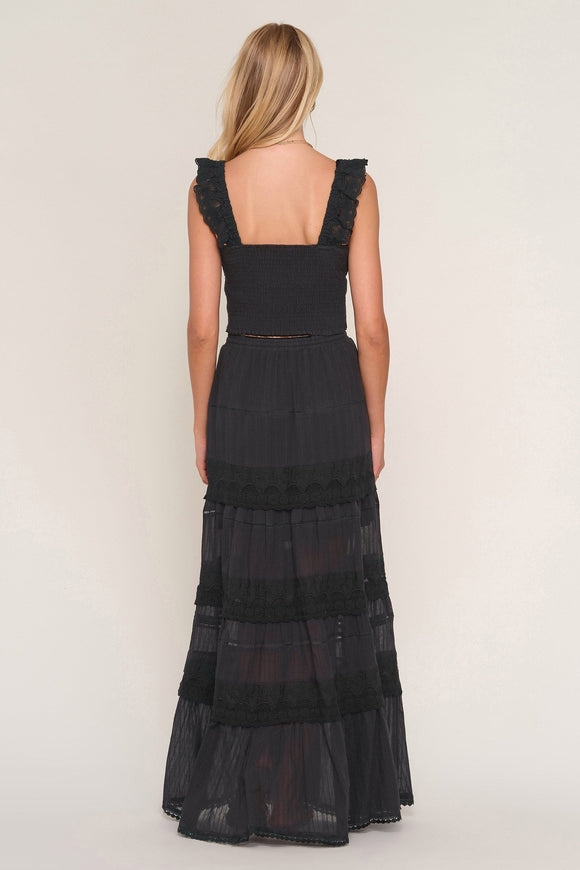 Black tiered dress worn by a person on a white background