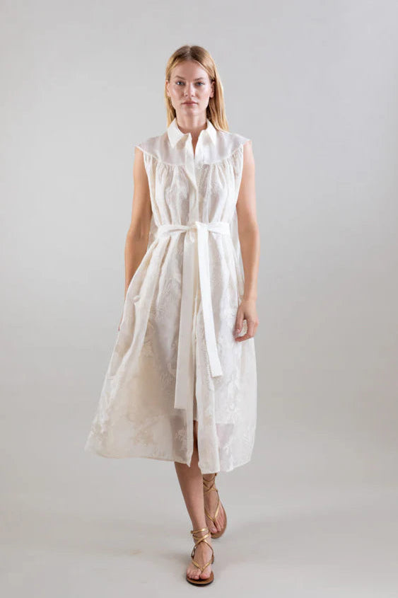 Woman wearing a white sleeveless dress on a plain background